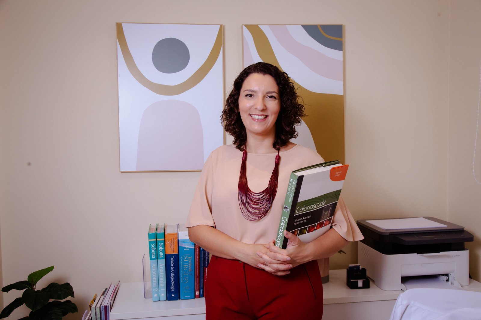Dra. Alessandra Cintra Amaral com o livro Colonoscopia, em seu consultório